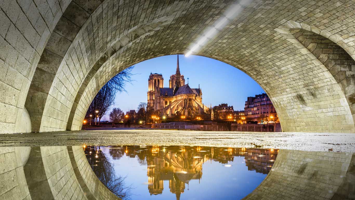 Notre Dame Cathedral reflected in a puddle under Pont de la Tournelle, Paris, France