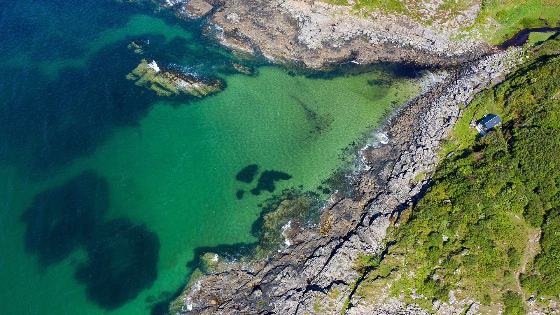 Aerial shot of waves lapping up onto rocks in Portuairk Bay, Ardnamurchan, Lochaber