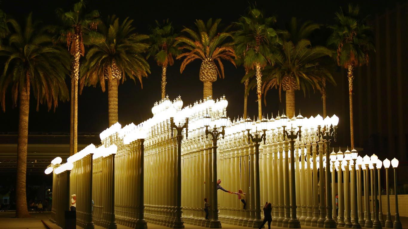 People in the 'Urban Light' sculpture by Chris Burden at LACMA in Los Angeles, California, USA