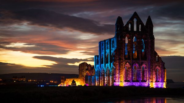 Whitby Abbey illuminated with coloured floodlights in North Yorkshire