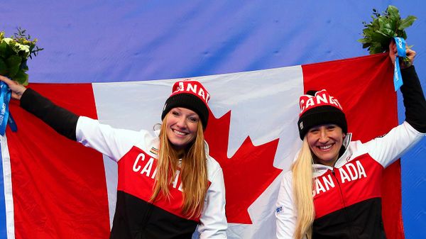 Kaillie Humphries (R) and Heather Moyse of Canada team 1 celebrate during the flower ceremony after winning the gold medal