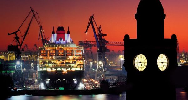 Die Queen Mary 2 im Trockendock des Hamburger Hafens, im Vordergrund der Pegelturm der St. Pauli-Landungsbrücken