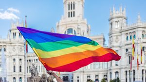 Brazos agitando la bandera LGBTQIA en la Plaza de Cibeles en Madrid, España (© Jose Gonzalez Buenaposada/Getty Images)(Bing España)