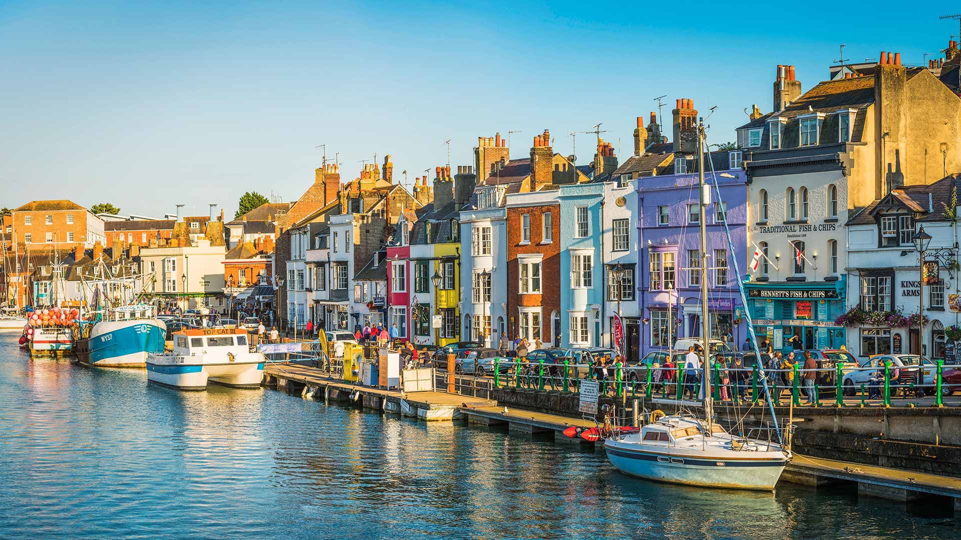Colourful cottages, fishing boats and yachts around the harbour in Weymouth, Dorset