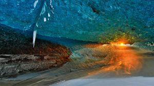 ｢氷の洞窟から見た夕日｣アイスランド, ヴァトナヨークトル氷河 (© Johnathan Ampersand Esper/Aurora Photos)(Bing Japan)