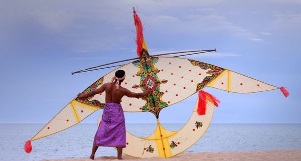 A Malaysian man holds a traditional handmade kite