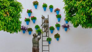 正在照看花草的孩子和祖父铜雕，西班牙科尔多瓦 (© David M G/Alamy)(Bing China)