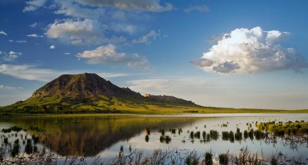 Bear Butte reflects into Bear Butte Lake near Sturgis, South Dakota, USA