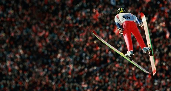 Skispringer im Flug mit Blick auf das Publikum