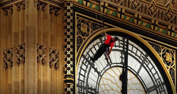 Workers carry out repairs to the clock faces on St Stephen's Tower in London, England