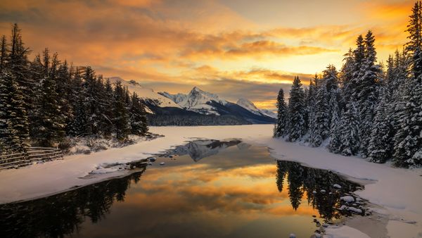 Scenic view of lake by snowcapped mountains in Banff, Alberta