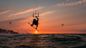 Silhouette eines springenden Kitesurfers bei Sonnenuntergang im baltischen Meer (© Jens Breuer/Getty Images)(Bing Deutschland)