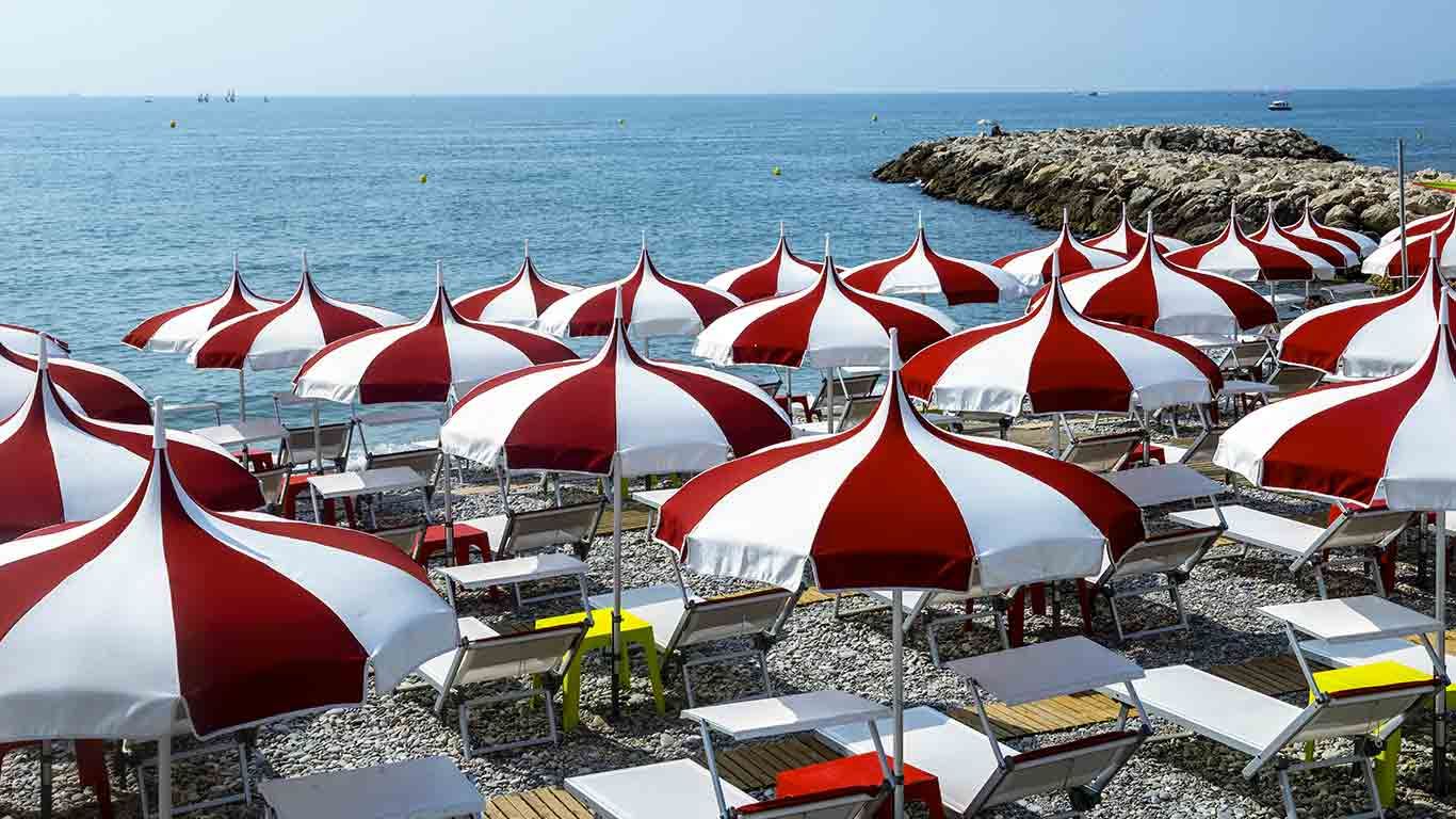 Parasols rouges et blancs sur une plage de Cagnes-sur-Mer, Provence-Alpes-Côte d'Azur, France