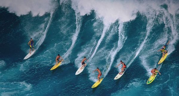 Surfers riding large wave, Hawaii