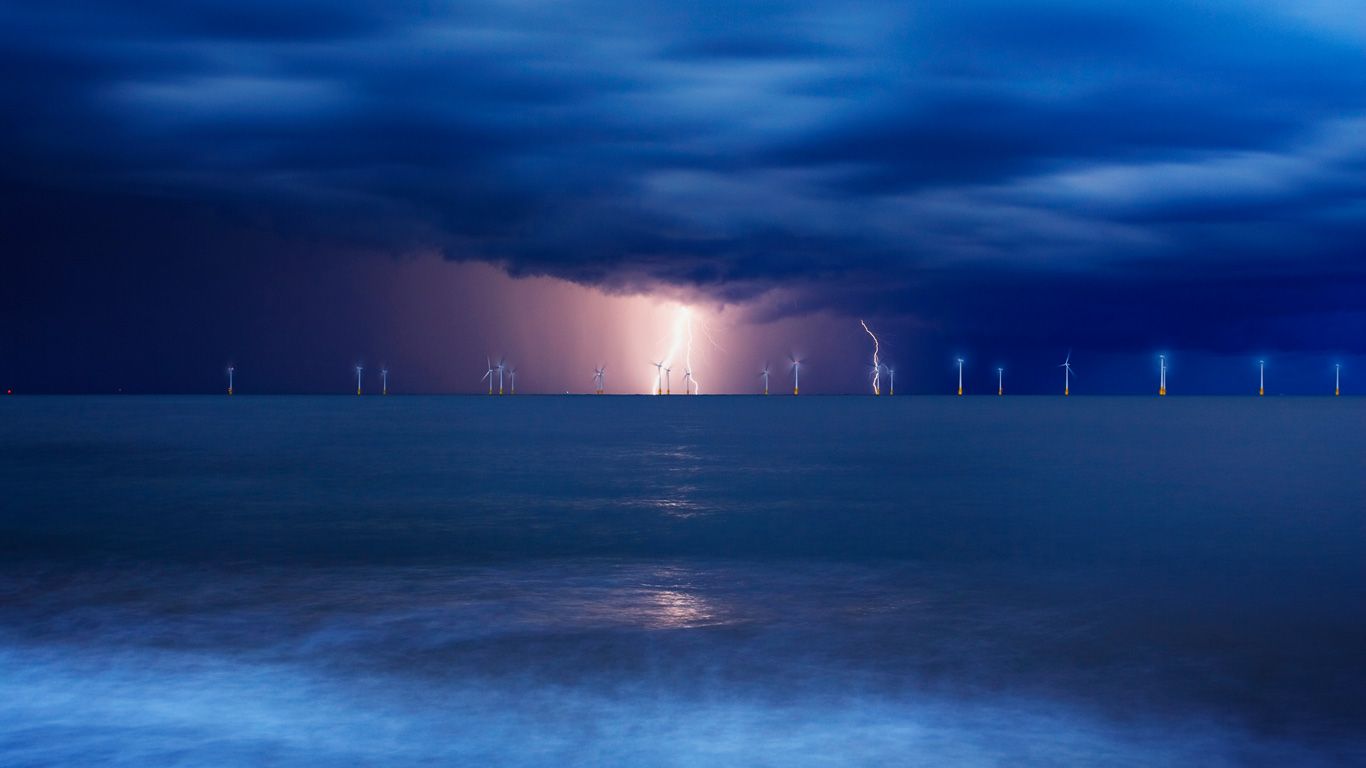 Offshore wind farm at Great Yarmouth in Norfolk in a lightning storm, England