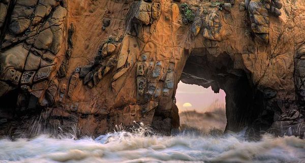 Waves and sea spray through a sea arch at Pfeiffer Beach in Big Sur, California, USA