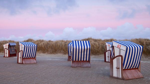 Strandkörbe im Abendrot am Nordstrand der Insel Borkum, Niedersachsen