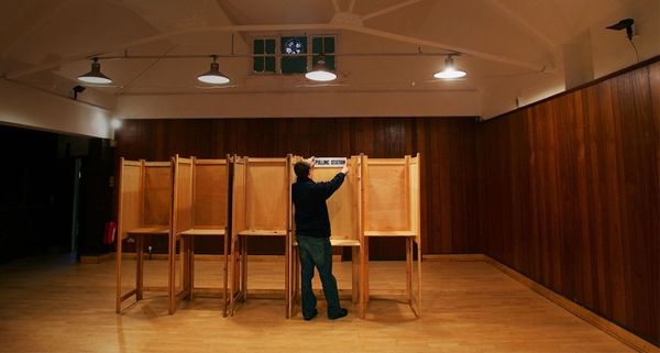 An election worker prepares the voting booths at Gunnersbury Triangle Social Club in west London