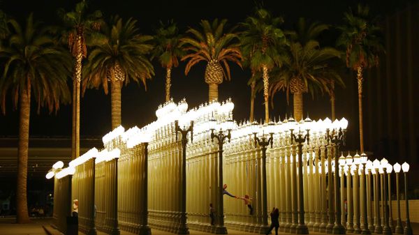 People in the 'Urban Light' sculpture by Chris Burden at LACMA in Los Angeles, California, USA