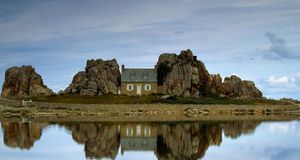 House between rocks is reflected in Brittany, France -- Axiom Photographic/Masterfile &copy; (Bing Australia)