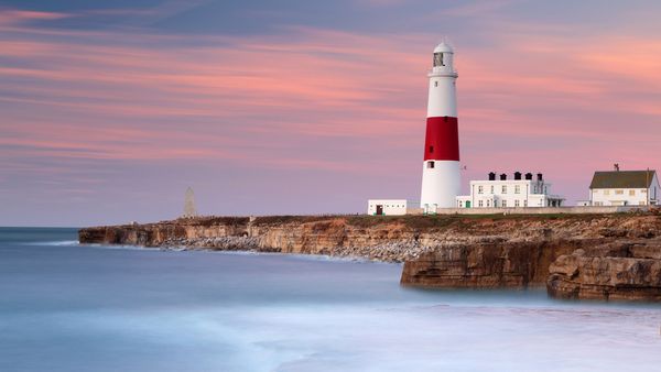 Dawn sunlight and waves at Portland Bill Lighthouse, Dorset, England
