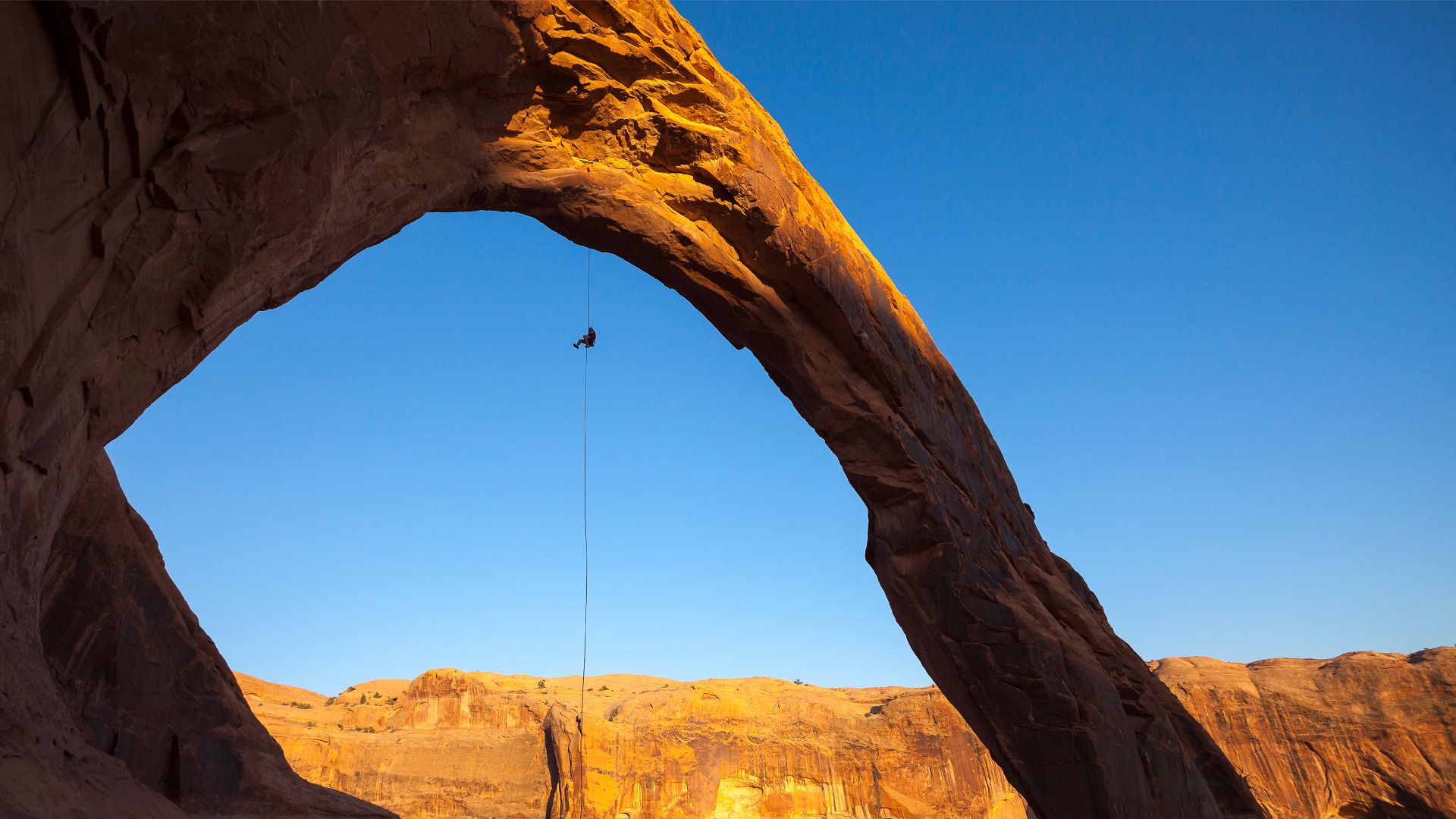 A man rappels off Corona Arch near Moab, Utah, United States